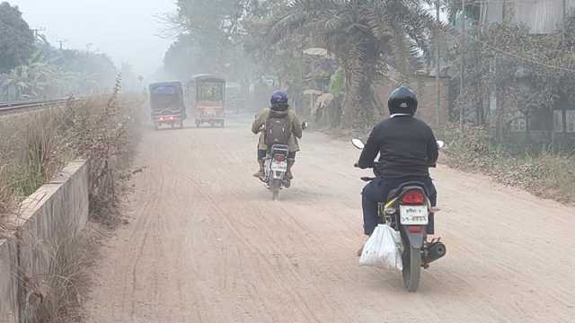 ট্রাক থেকে ঝরে পড়া বালুর স্তর সড়কে